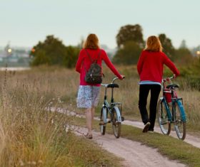 Woman pushing bicycle home Stock Photo