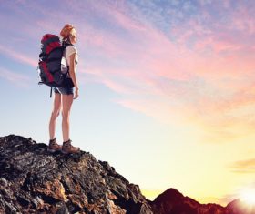 Woman standing on the mountain top watching the sunrise Stock Photo