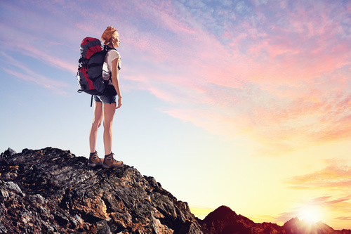 Woman standing on the mountain top watching the sunrise Stock Photo