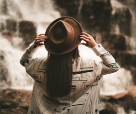 Woman with hat looking at waterfall Stock Photo