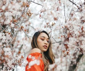 Young asian girl posing with blooming flowers Stock Photo