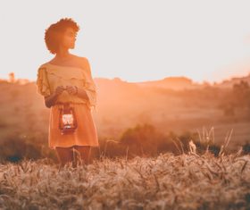 Young black woman posing on field at dusk Stock Photo
