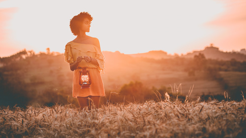 Young black woman posing on field at dusk Stock Photo