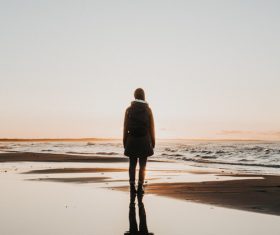 Young girl standing alone on seaside Stock Photo