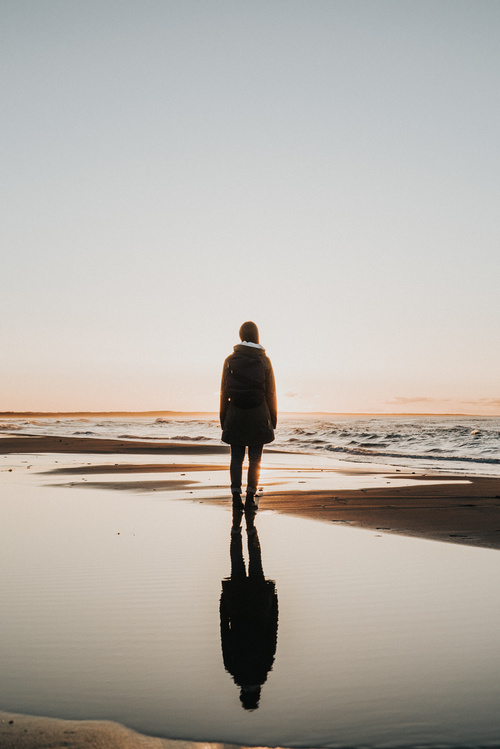 Young girl standing alone on seaside Stock Photo