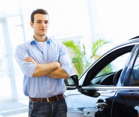 Young man standing next to new car Stock Photo