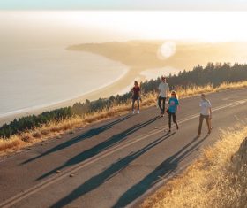 Young man walking on the road in the sun Stock Photo