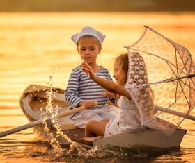 little boy boating on the lake with little girl Stock Photo 06