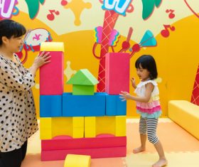 little girl and her mother together to build blocks Stock Photo