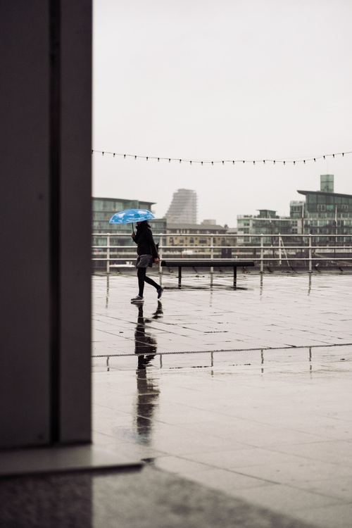 woman walking under rainy weather Stock Photo