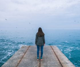 woman watching sea scenery on jetty Stock Photo