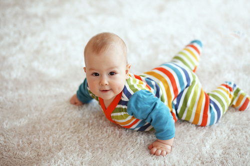 Baby lying on the carpet Stock Photo