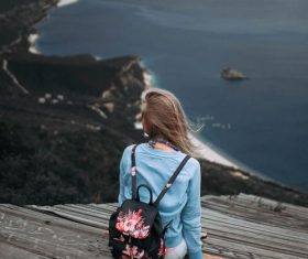 Beautiful woman sitting on the steps by the sea Stock Photo