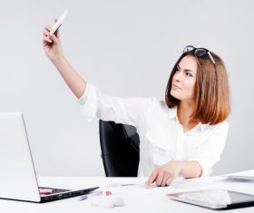 Business woman using cell phone in the office selfie 03