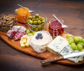 Cheese jam and sausage with pickled olives on cutting board Stock Photo 01