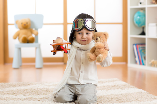 Child holding teddy bear play wooden plane Stock Photo 01