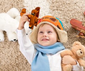 Child holding teddy bear play wooden plane Stock Photo 02