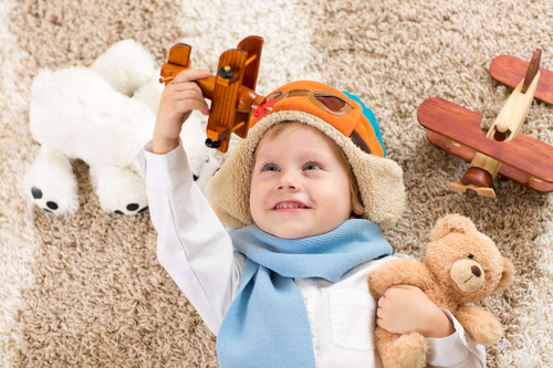 Child holding teddy bear play wooden plane Stock Photo 02