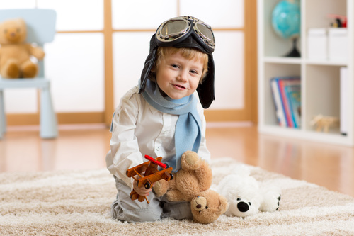 Child holding teddy bear play wooden plane Stock Photo 03