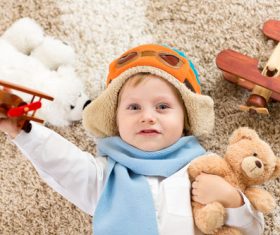 Child holding teddy bear play wooden plane Stock Photo 04