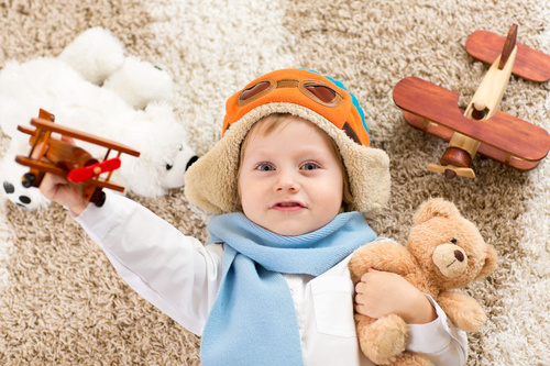 Child holding teddy bear play wooden plane Stock Photo 04