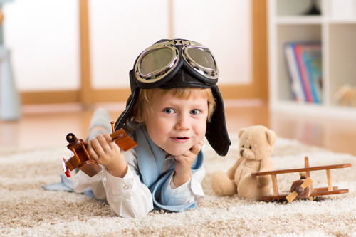 Child playing with wooden plane on the carpet Stock Photo 01