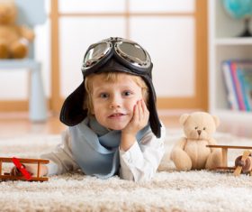 Child playing with wooden plane on the carpet Stock Photo 02