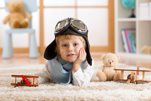 Child playing with wooden plane on the carpet Stock Photo 02