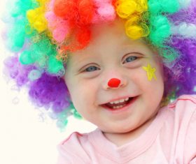 Child with colorful wig and red nose Stock Photo