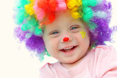 Child with colorful wig and red nose Stock Photo