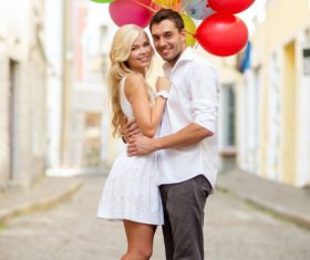 Couple holding colorful balloons on the street Stock Photo 01