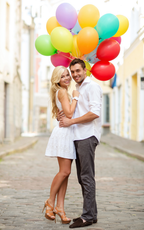 Couple holding colorful balloons on the street Stock Photo 01