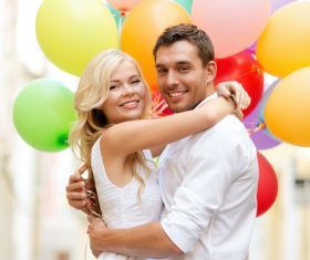 Couple holding colorful balloons on the street Stock Photo 02