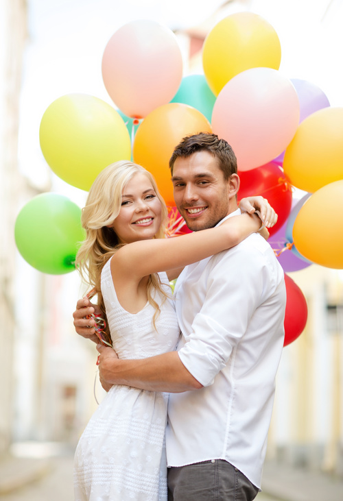 Couple holding colorful balloons on the street Stock Photo 02