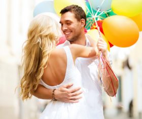 Couple holding colorful balloons on the street Stock Photo 04