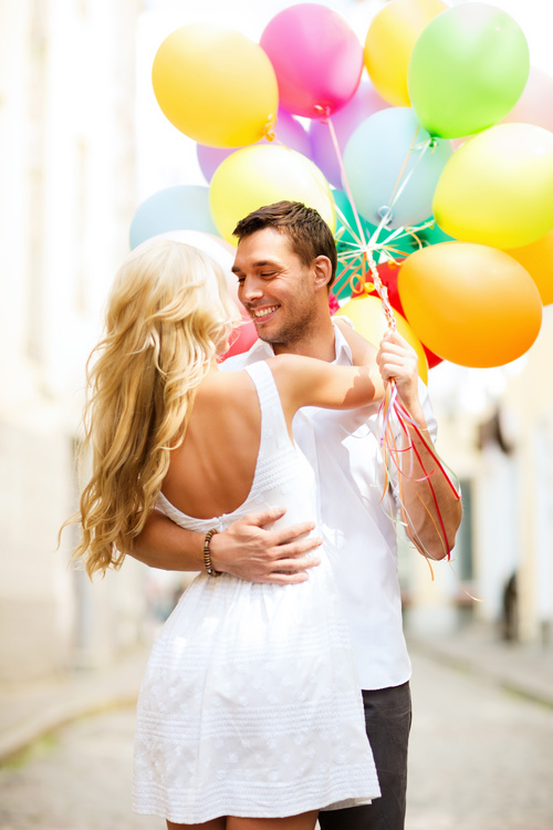 Couple holding colorful balloons on the street Stock Photo 04