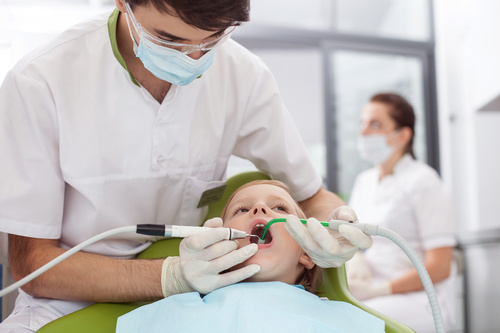 Dentist treats tooth decay for little boy Stock Photo 01