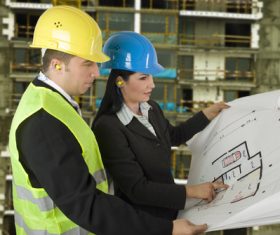 Engineer looking at drawings at construction site Stock Photo