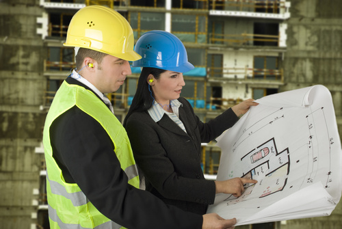 Engineer looking at drawings at construction site Stock Photo