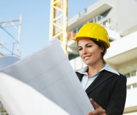 Female engineer looking at drawings at construction site Stock Photo