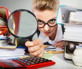 Female secretary holding a magnifying glass Stock Photo