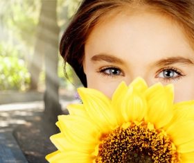 Girl holding sunflower flower covering face Stock Photo