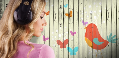 Girl listening to music standing in front of cartoon painted wall background Stock Photo 01