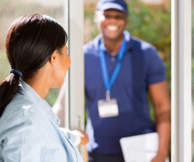 Girl opens the door waiting for express delivery Stock Photo