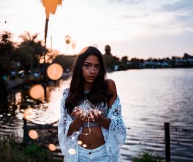 Girl standing at the river at dusk holding lantern Stock Photo