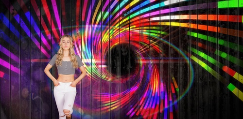 Girl standing in front of a colorful background wall wearing headphones Stock Photo