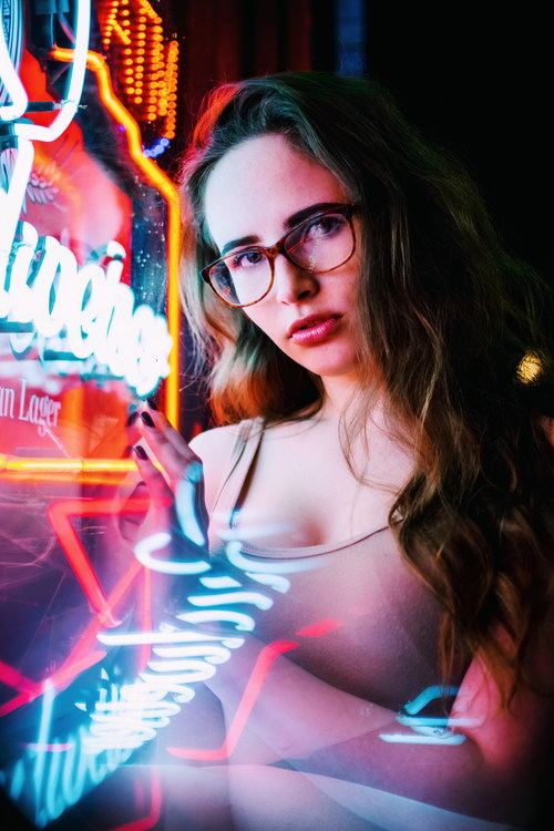 Girl standing next to the neon Stock Photo