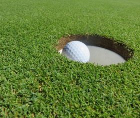 Golf ball in the hole Stock Photo