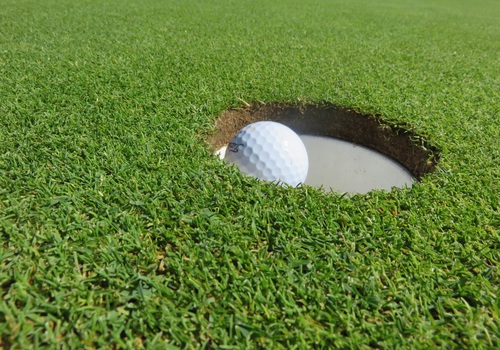 Golf ball in the hole Stock Photo