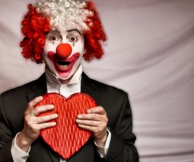 Hand holding heart shaped white clown Stock Photo